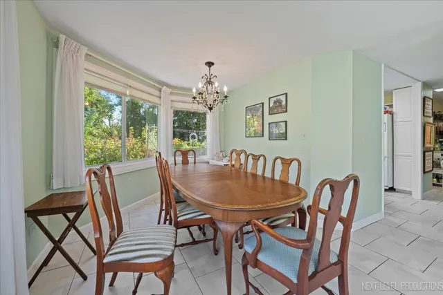 a dining room with furniture a rug and a floor to ceiling window