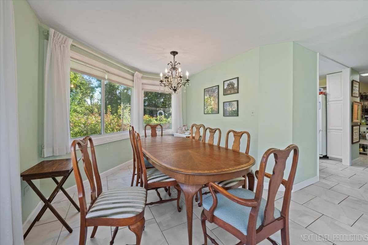 7N384 Whispering Willows Street St. Charles, IL 60174 - Photo 8 of 48 a dining room with furniture a rug and a floor to ceiling window