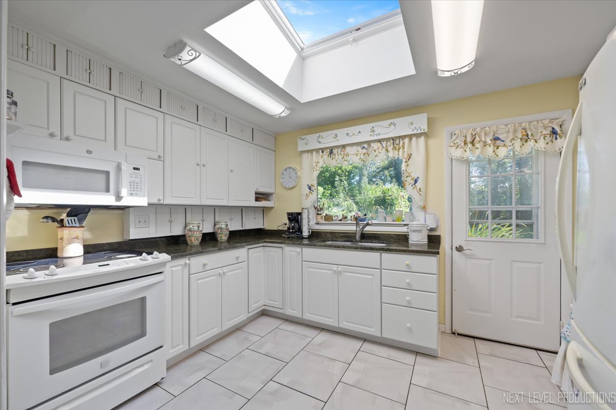 7N384 Whispering Willows Street St. Charles, IL 60174 - Photo 9 of 48 a kitchen with white cabinets and white appliances