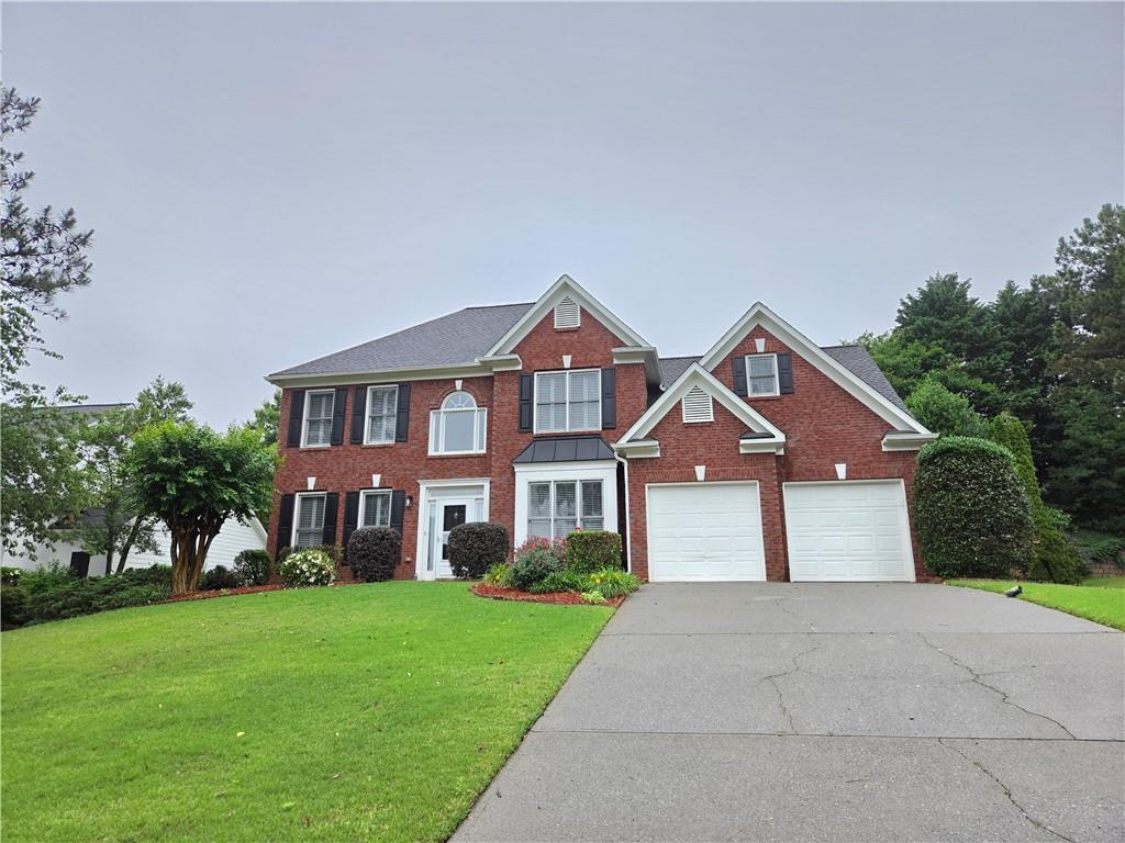 3715 Ridgeside Court Suwanee, GA 30024 - Photo 2 of 44 a front view of a house with a yard and trees