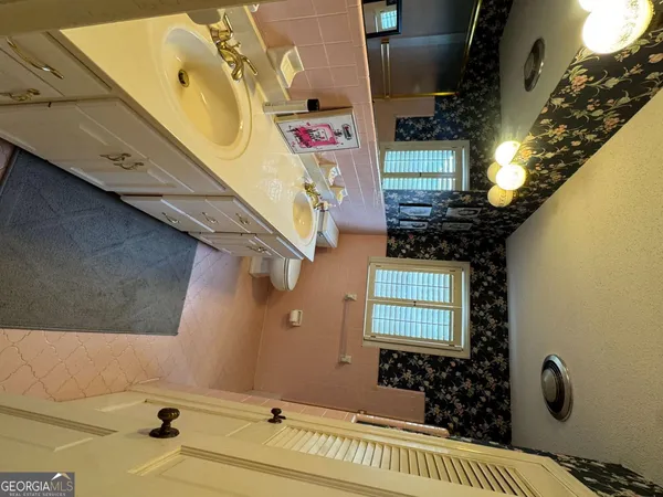 a kitchen with a sink dishwasher a stove a microwave oven a dining table and chairs with wooden floor