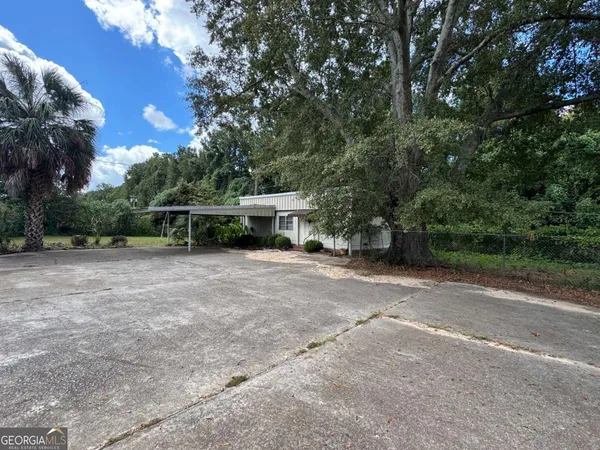 a view of backyard with a table and chairs under an umbrella