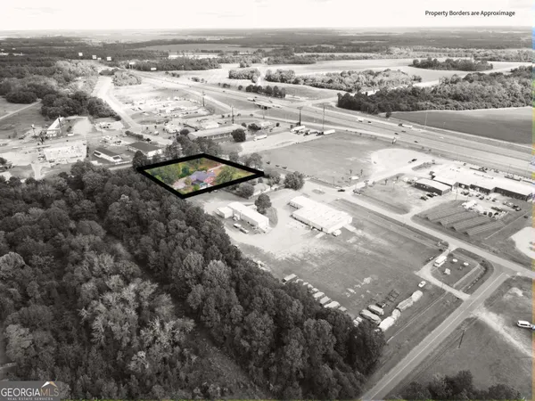 an aerial view of a house with yard and green space
