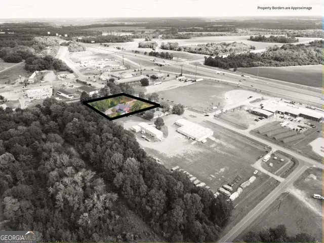 an aerial view of a house with yard and green space