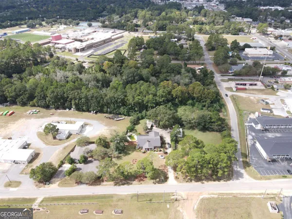 an aerial view of a house with yard and street