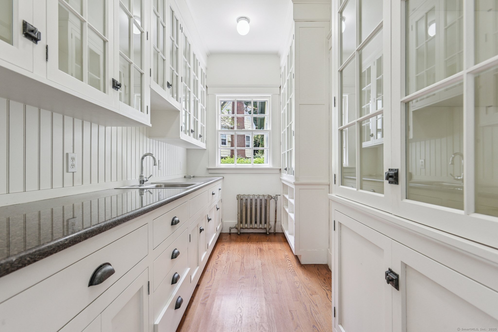 1056 Whitney Avenue Hamden, CT 06517 - Photo 13 of 40 a kitchen with granite countertop white cabinets and wooden floor