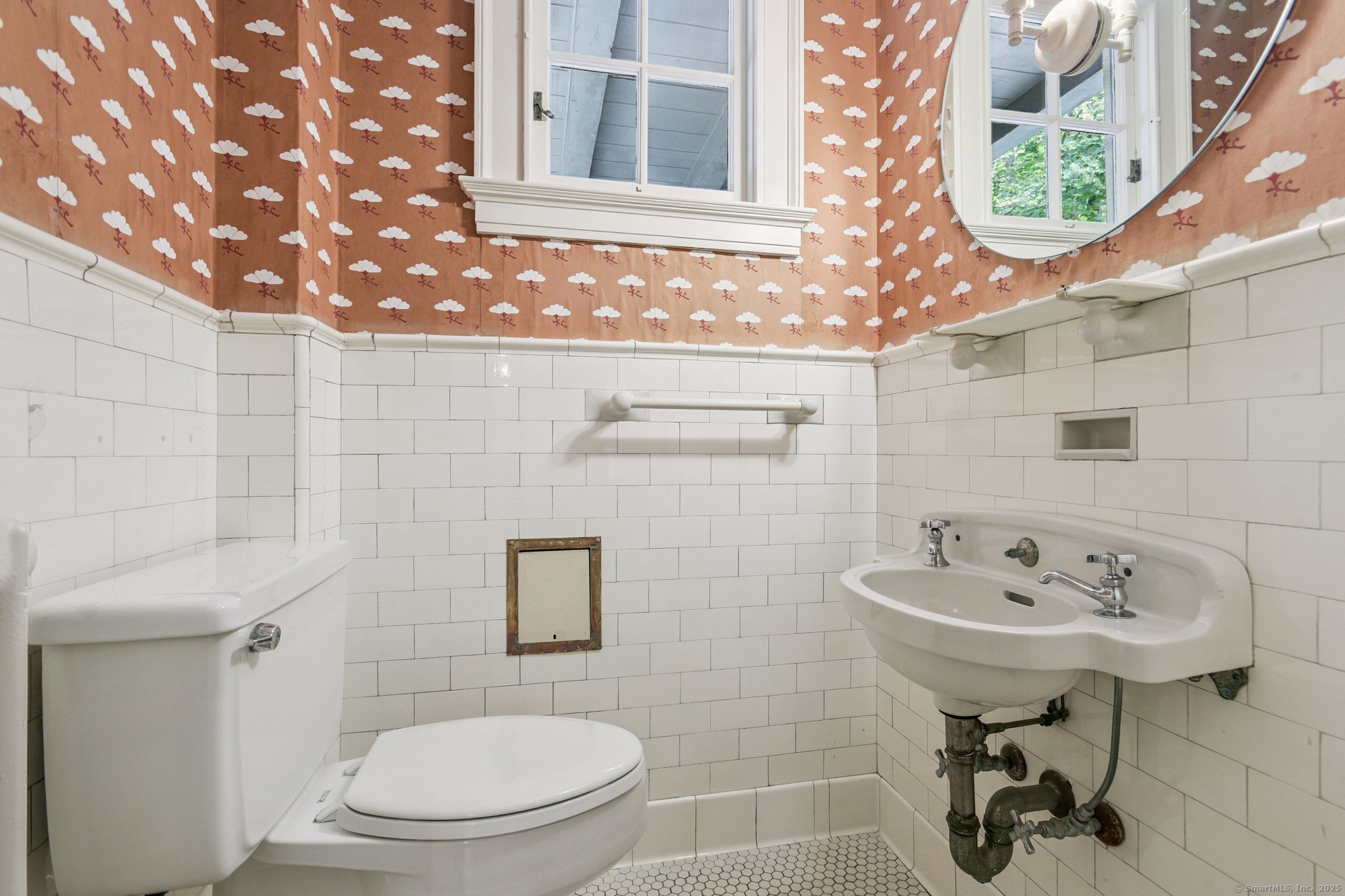 1056 Whitney Avenue Hamden, CT 06517 - Photo 19 of 40 a bathroom with a sink a toilet and a mirror