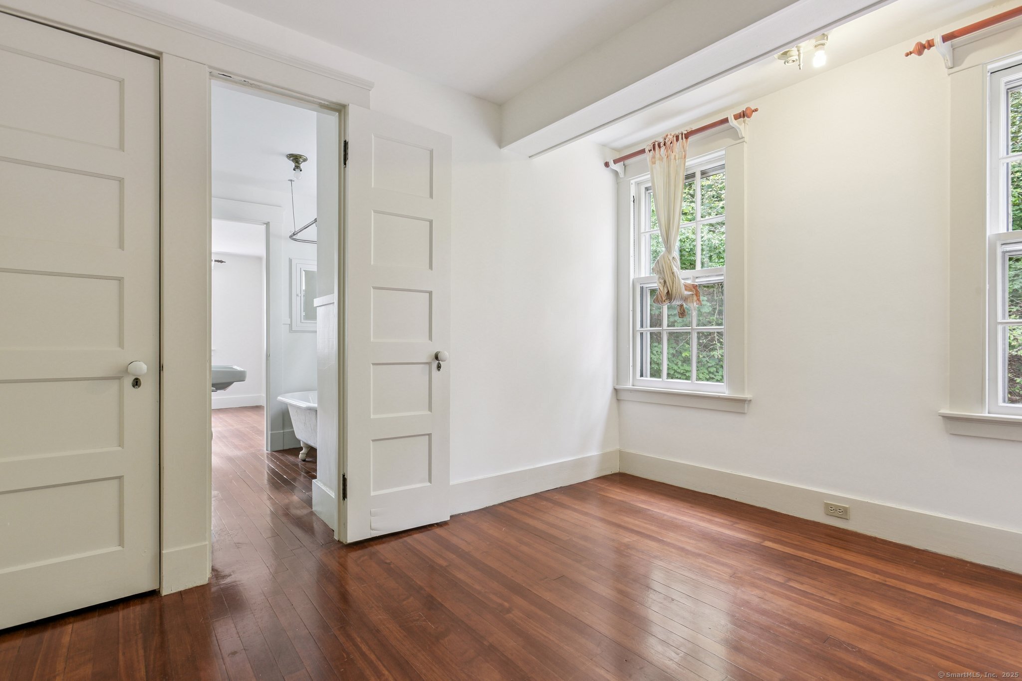 1056 Whitney Avenue Hamden, CT 06517 - Photo 33 of 40 a view of an empty room with wooden floor and a window