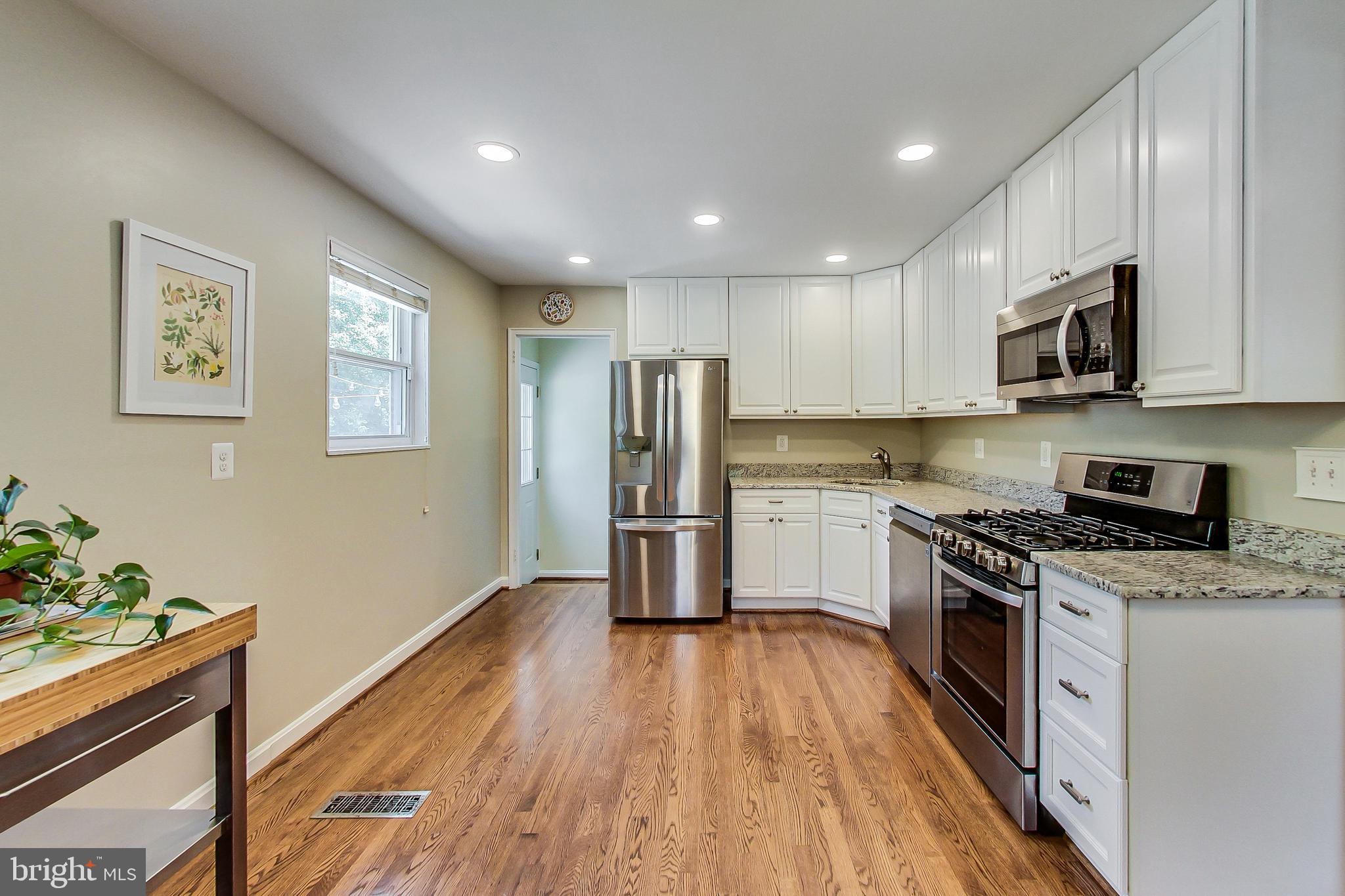 4715 Oxbow Road Rockville, MD 20852 - Photo 5 of 35 a kitchen with granite countertop a refrigerator a stove top oven a sink dishwasher and wooden floor