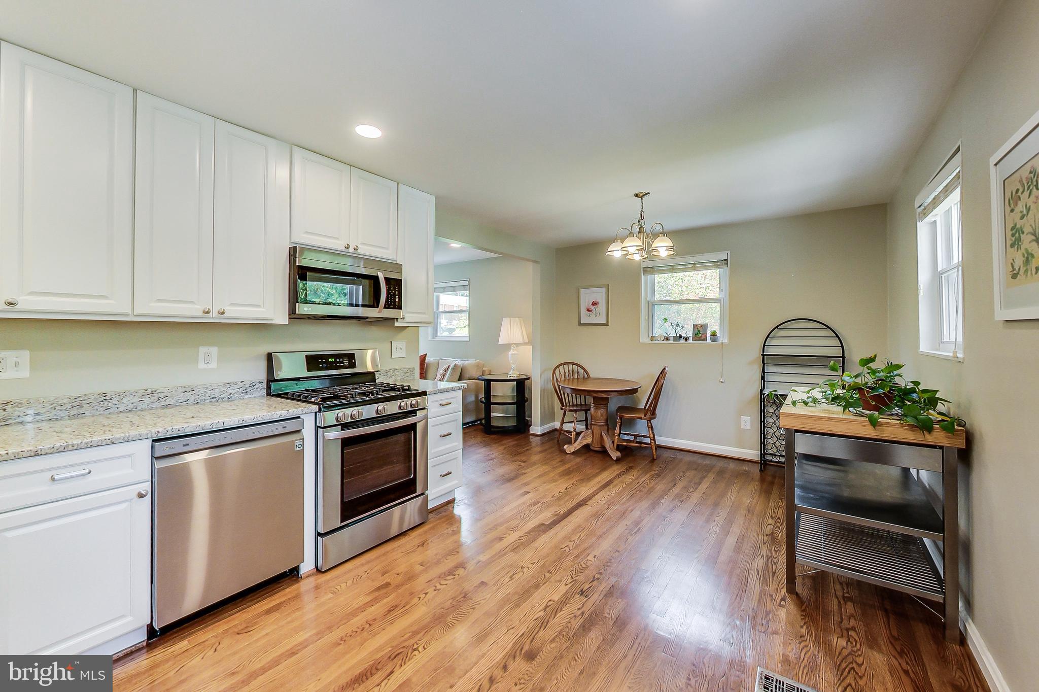 4715 Oxbow Road Rockville, MD 20852 - Photo 7 of 35 a kitchen with sink cabinets and dining table