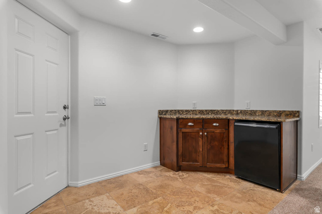 439 East 13540 South Draper, UT 84020 - Photo 27 of 46 Wet bar featuring wood cabinetry, stone-finish countertop, and under-counter refrigeration