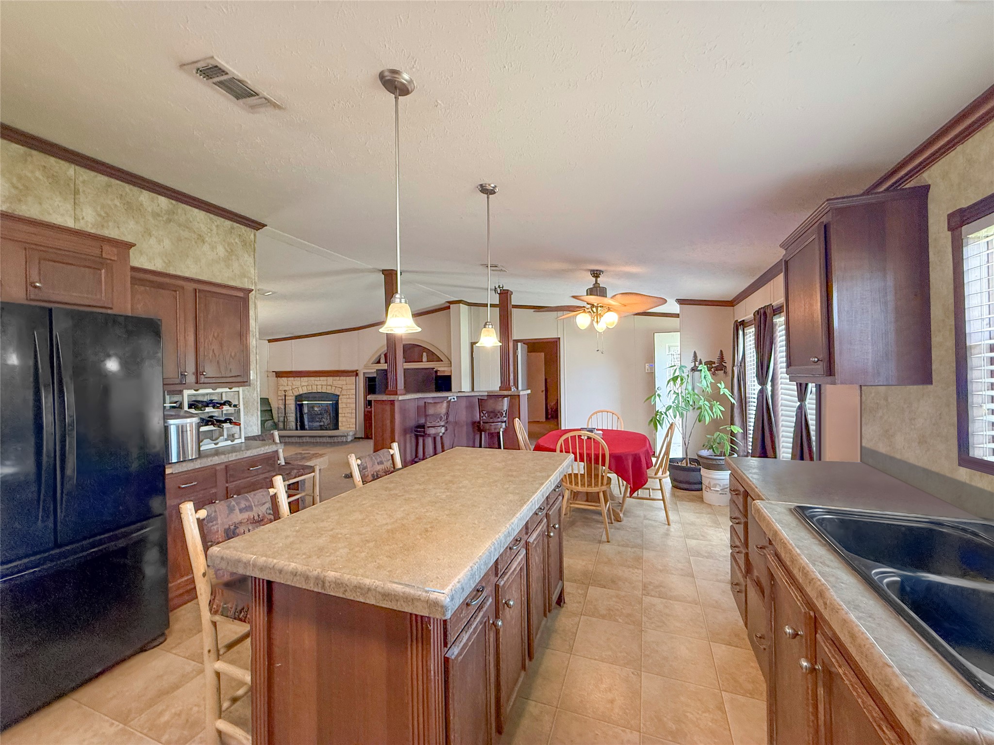 845 Caldwell Street Lexington, TX 78947 - Photo 2 of 39 Kitchen featuring freestanding refrigerator, crown molding, a center island, pendant lighting, and ceiling fan