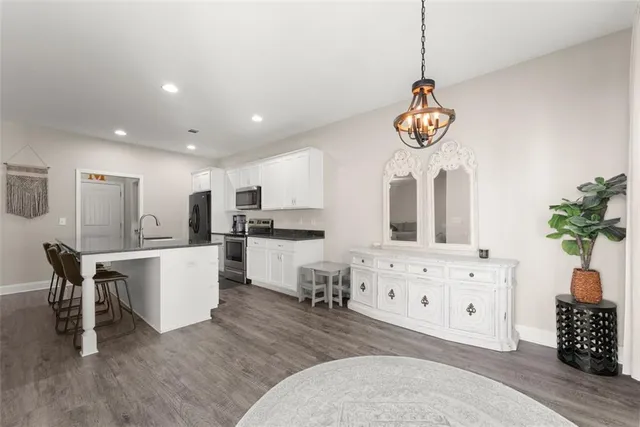 a view of kitchen with refrigerator microwave and white cabinets