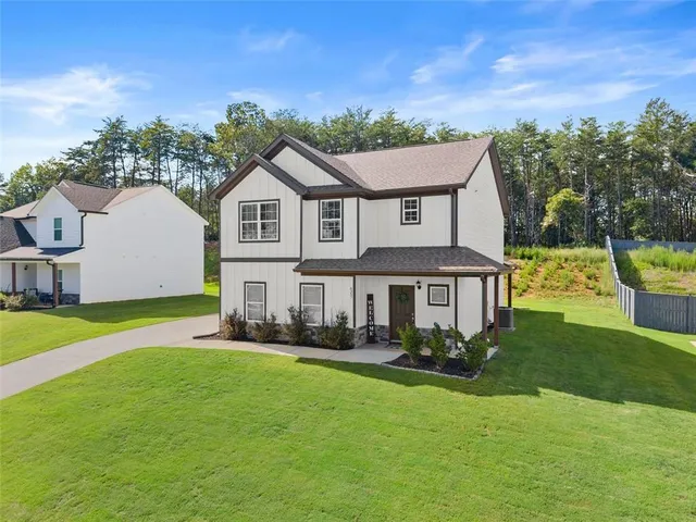 a front view of a house with a garden and plants