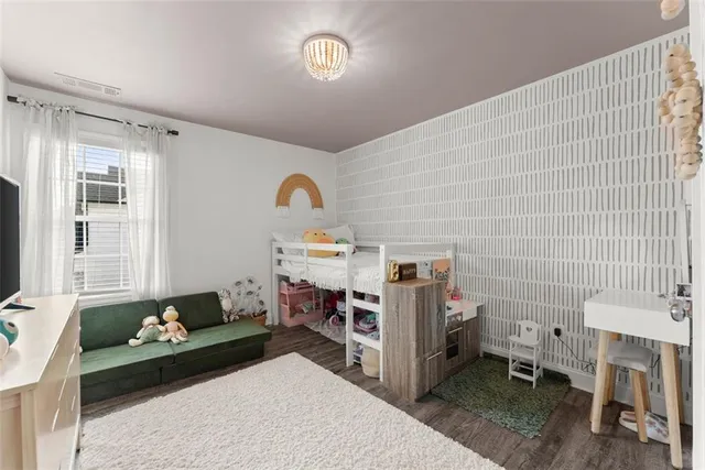 a hotel room with a bed and flat screen tv