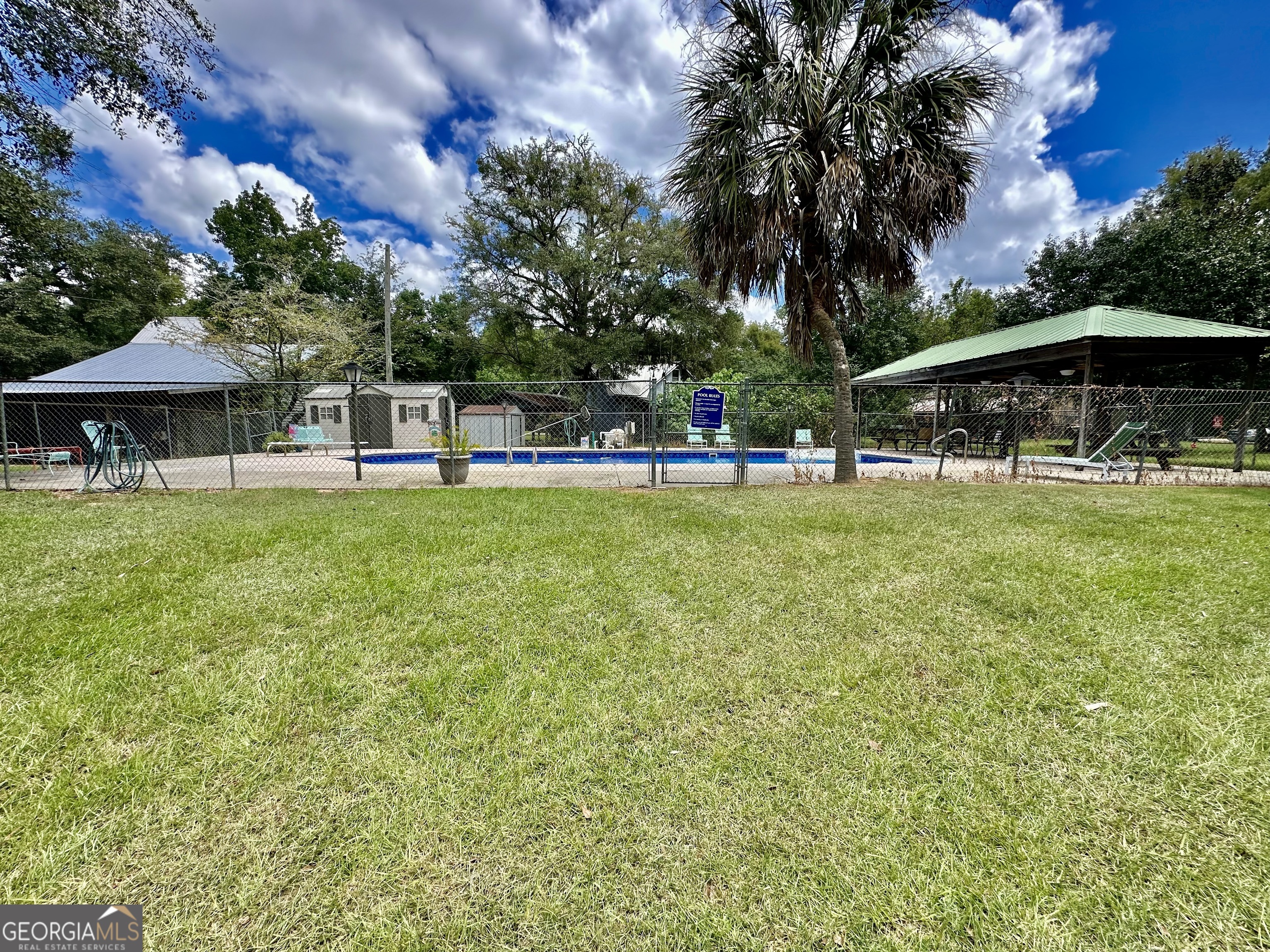 226 Cherokee Road Glenwood, GA 30428 - Photo 76 of 117 a view of a swimming pool with a table and chairs under an umbrella