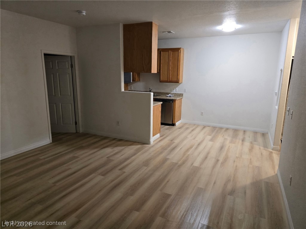 4730 East Craig Road, Unit 1062 Las Vegas, NV 89115 - Photo 2 of 8 Laminate flooring connects the living area to a compact, functional kitchen space.