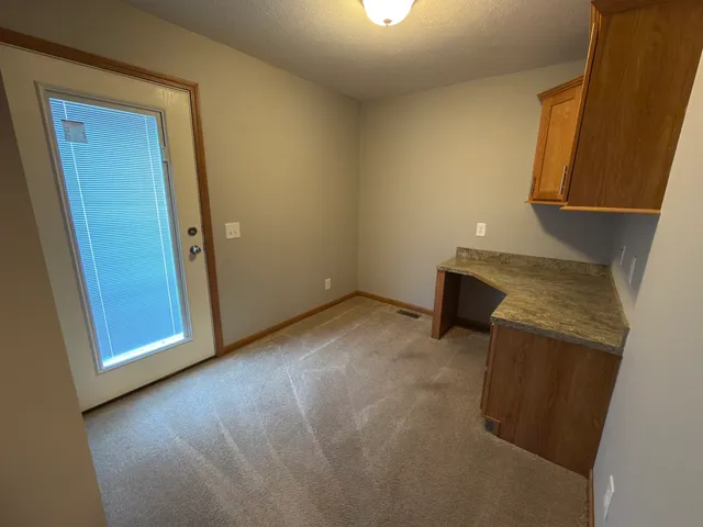 an empty room with wooden floor and a sink
