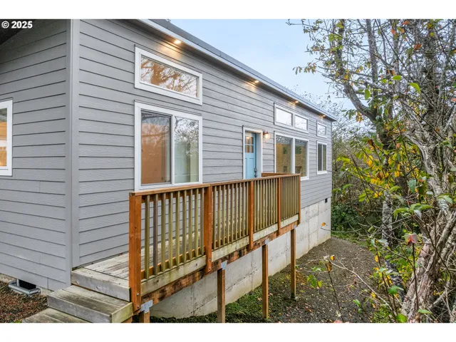 a view of a house with a small yard and wooden floor and fence