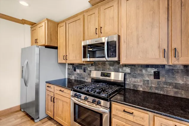 a kitchen with stainless steel appliances granite countertop a refrigerator stove and microwave