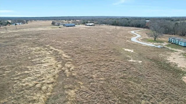 a view of a dry yard with wooden fence