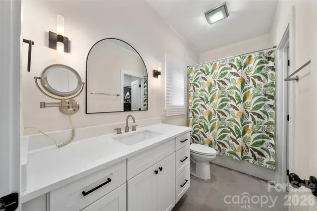 a bathroom with a sink a toilet and a mirror