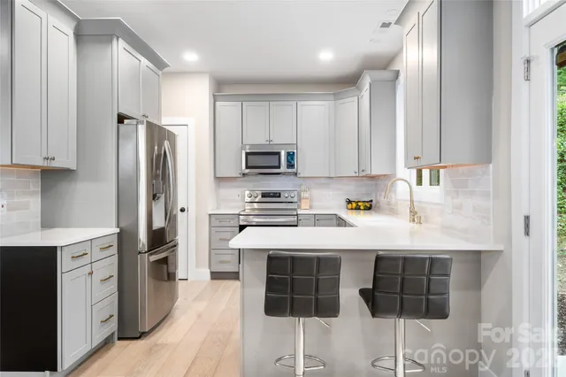 a kitchen with stainless steel appliances a stove refrigerator sink and cabinets