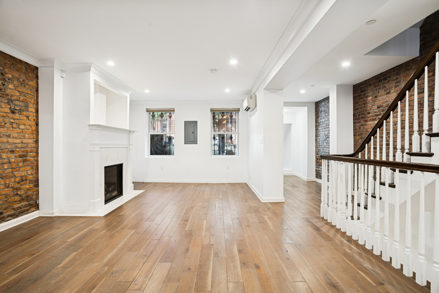 a view of a livingroom with wooden floor and staircase