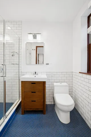 a bathroom with a toilet a sink and mirror