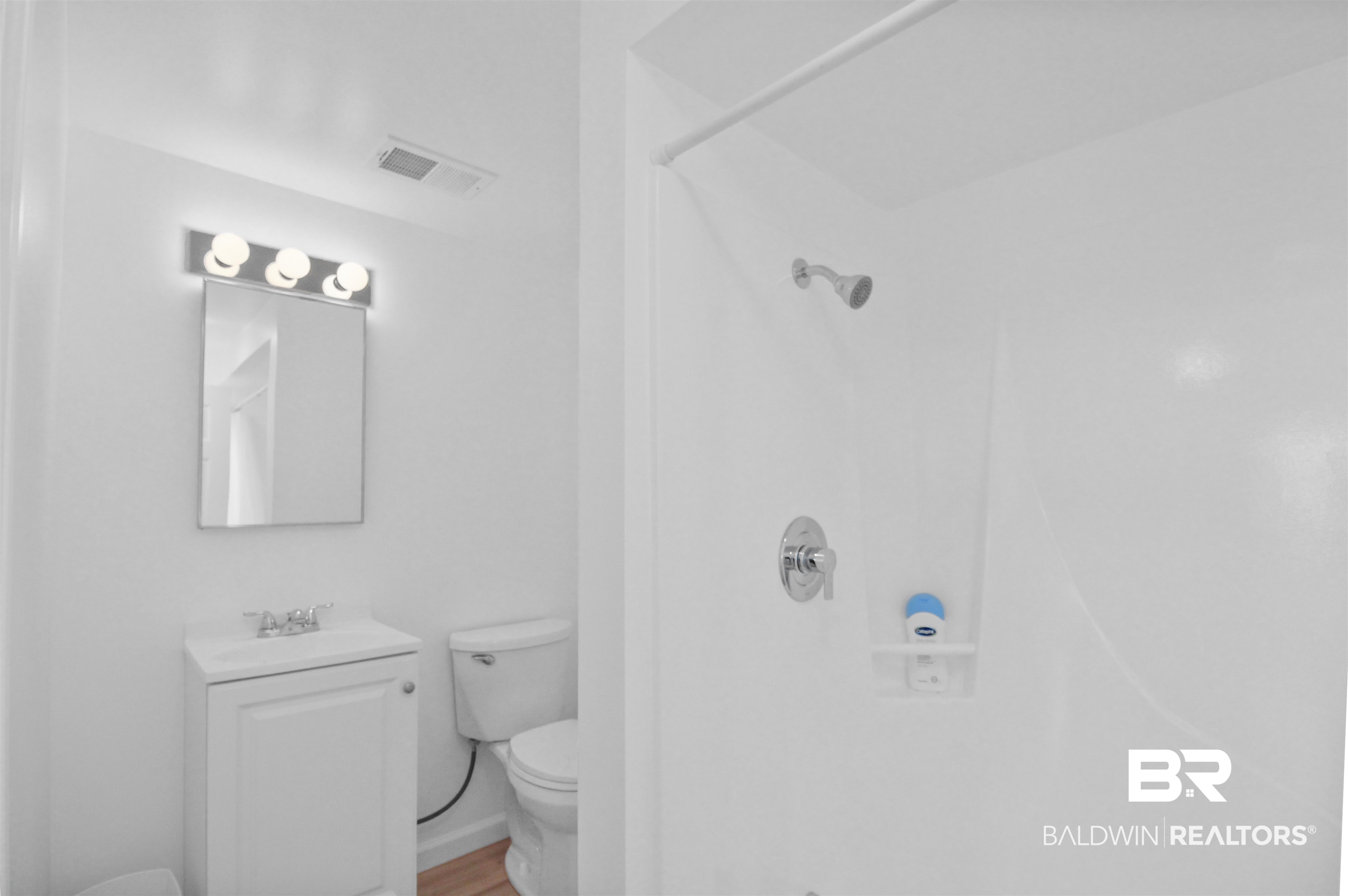 17622 Brewer Road Foley, AL 36535 - Photo 7 of 26 Full bathroom with vanity, a walk in shower, and wood finished floors