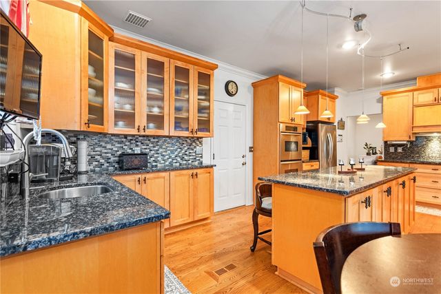 a kitchen with stainless steel appliances granite countertop a sink and a large window