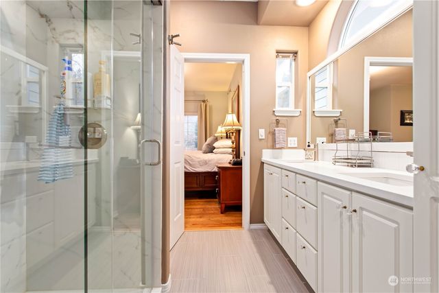 a en suite bathroom with a double vanity sink a large mirror and shower