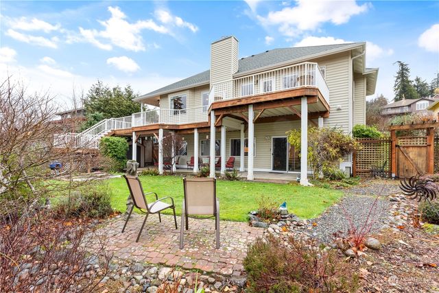 a view of a chair and table in backyard of the house