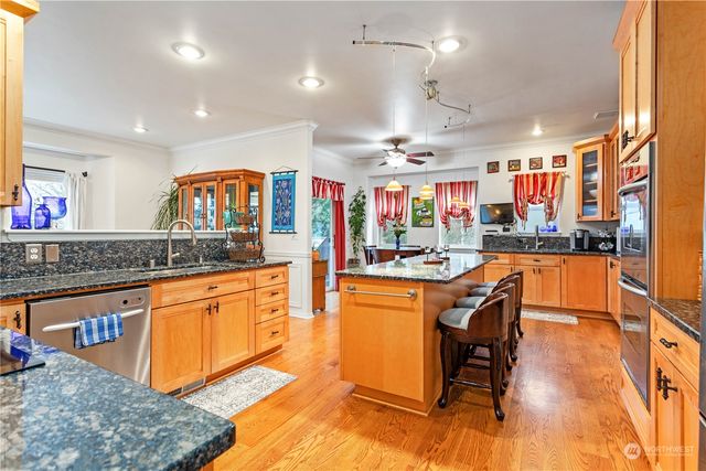 a large kitchen with stainless steel appliances kitchen island granite countertop a stove a sink a dining table and chairs