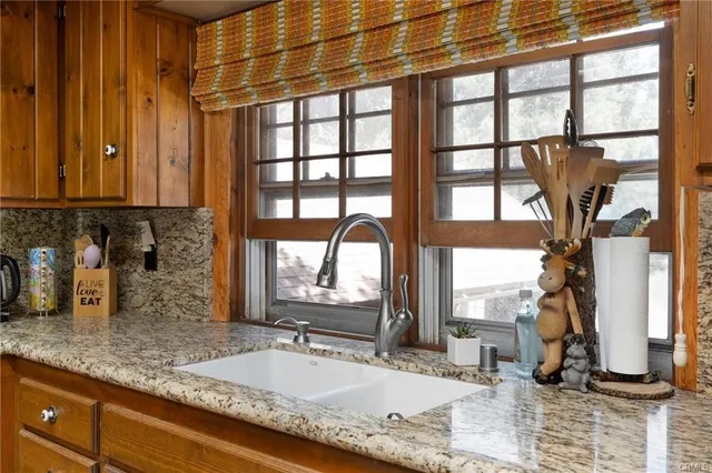 a bathroom with a granite countertop sink and a window