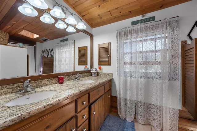 a bathroom with a granite countertop sink and a shower