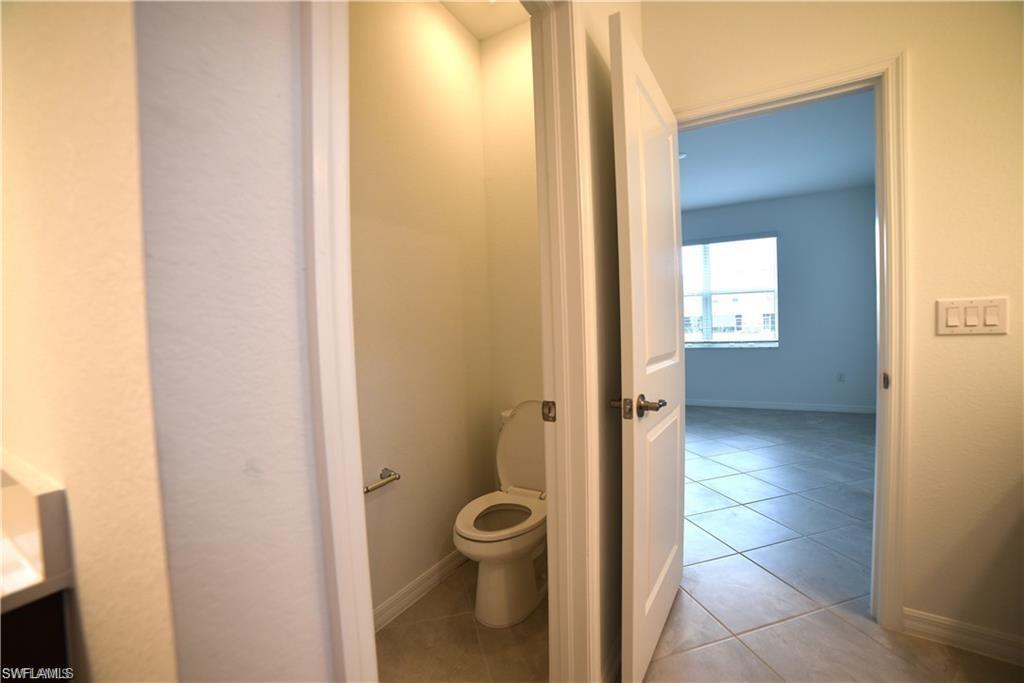 2665 Vine Avenue Naples, FL 34120 - Photo 14 of 30 a bathroom with a granite countertop toilet and a shower