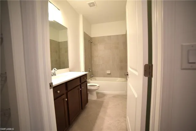 a bathroom with a granite countertop toilet and a shower
