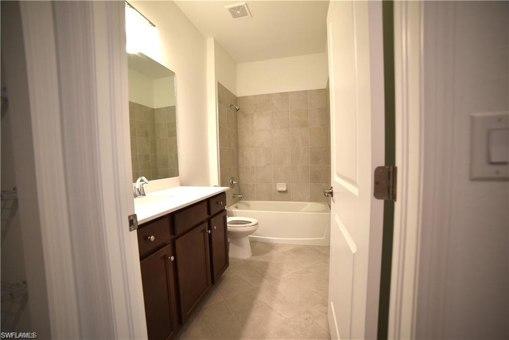 2665 Vine Avenue Naples, FL 34120 - Photo 15 of 30 a bathroom with a granite countertop sink a toilet and shower