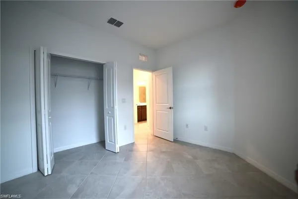 an empty room with windows and cabinet