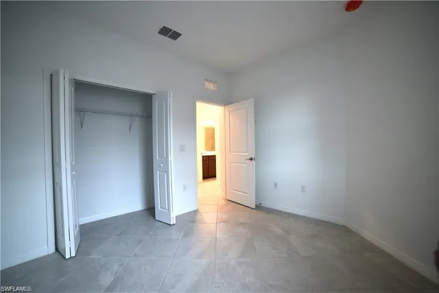 an empty room with windows and cabinet