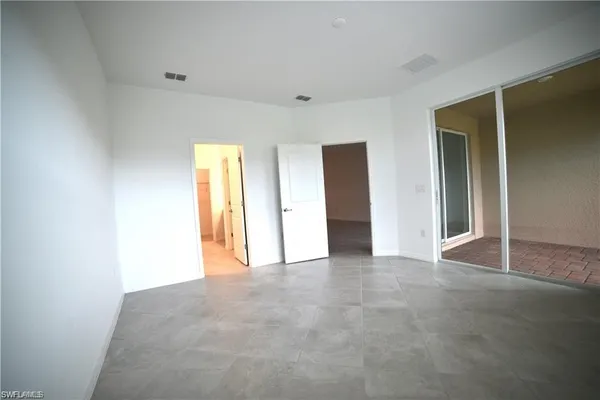an empty room with closet and a window