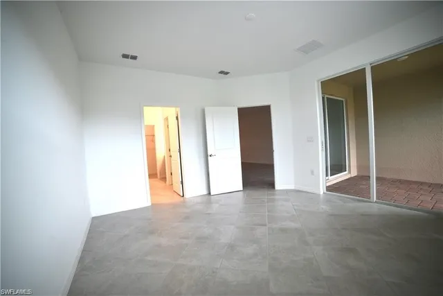 an empty room with closet and a window