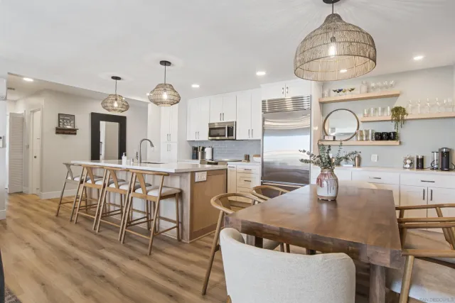 a living room with furniture a rug and kitchen view