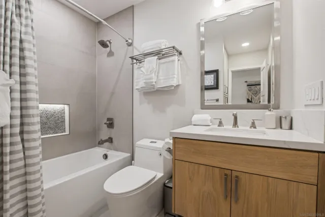 a bathroom with a granite countertop sink toilet and a mirror
