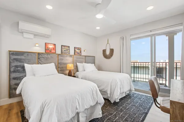 a bedroom with two beds and a large window