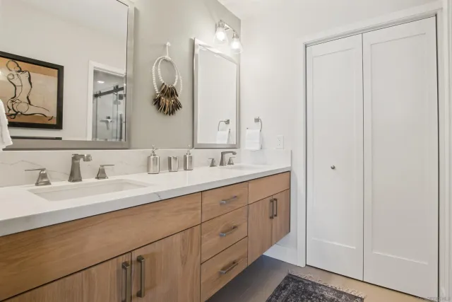 a bathroom with double sink and a mirror