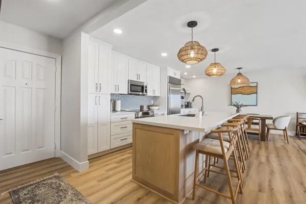 a view of kitchen with sink microwave refrigerator dining table and chairs