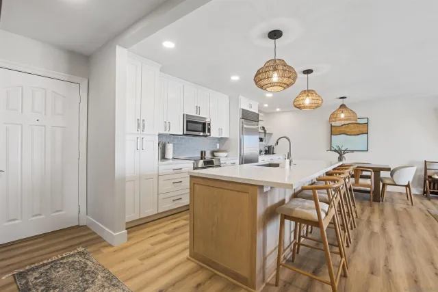a view of kitchen with sink microwave refrigerator dining table and chairs