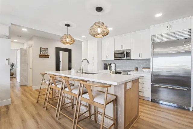 a kitchen with stainless steel appliances granite countertop a stove a refrigerator a oven a sink with a dining table and chairs